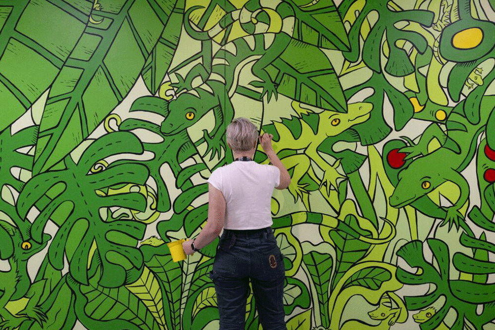 Wendy Dixon-Whiley painting the green mural.