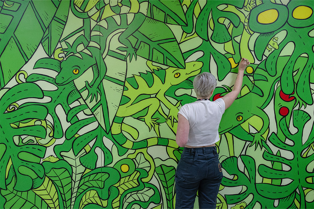 Wendy Dixon-Whiley painting the green mural.